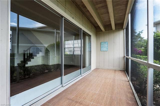 25484 Cockleshell Dr, #901, Bonita Springs, FL 34135 Unfurnished sunroom with healthy amount of natural light and beamed ceiling