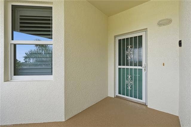 11041 Gulf Reflections Dr, #403, Fort Myers, FL 33908 Textured exterior finish with a security screen door, decorative grilles, and a single-hung window
