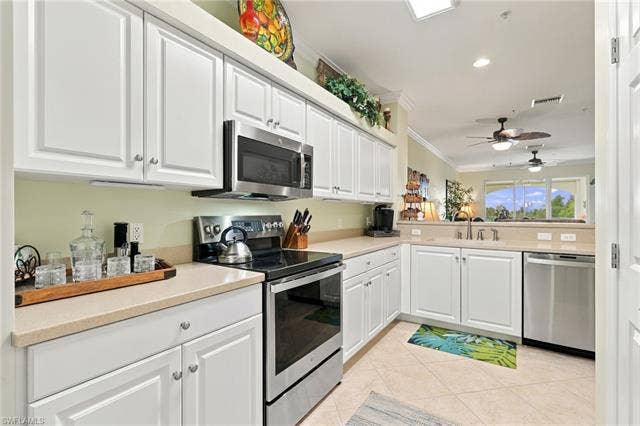 11041 Gulf Reflections Dr, #403, Fort Myers, FL 33908 Kitchen featuring white cabinetry, light-colored countertops, stainless steel appliances, and tiled flooring