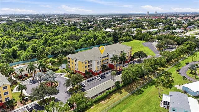 11041 Gulf Reflections Dr, #403, Fort Myers, FL 33908 Three-story building with a light yellow and red exterior