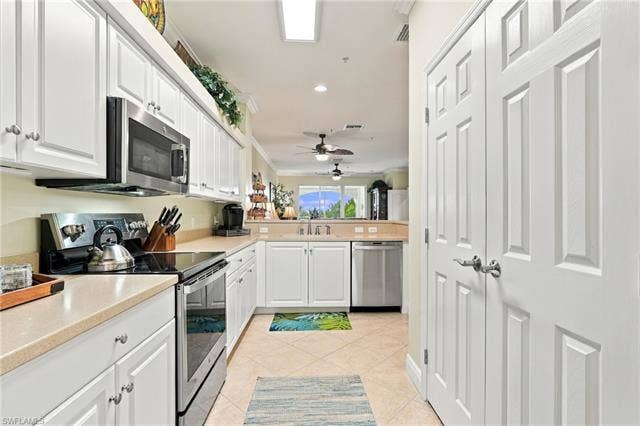 11041 Gulf Reflections Dr, #403, Fort Myers, FL 33908 White cabinetry with brushed nickel hardware, stainless steel appliances, light-toned countertops, and tiled flooring