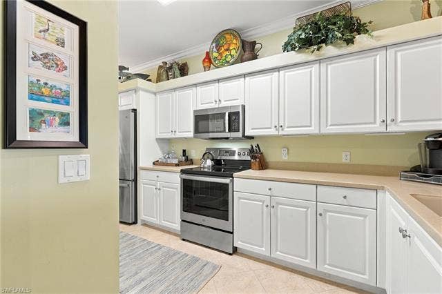 11041 Gulf Reflections Dr, #403, Fort Myers, FL 33908 White cabinetry, stainless steel appliances, neutral countertops, and tile flooring