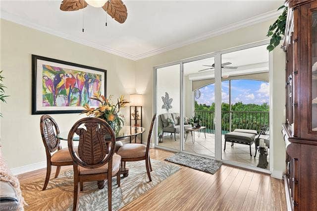 11041 Gulf Reflections Dr, #403, Fort Myers, FL 33908 Wood-finish flooring, crown molding, and a ceiling fan with leaf-shaped blades