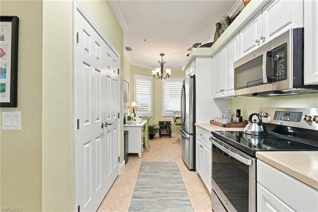 11041 Gulf Reflections Dr, #403, Fort Myers, FL 33908 Galley kitchen featuring white cabinetry, light-toned countertops, and stainless steel appliances