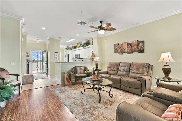 11041 Gulf Reflections Dr, #403, Fort Myers, FL 33908 Open-concept living area featuring wood-finish flooring, crown molding, and a ceiling fan