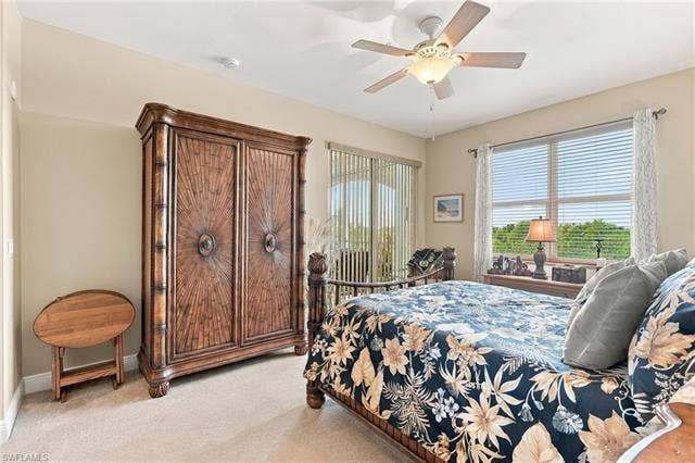 11041 Gulf Reflections Dr, #403, Fort Myers, FL 33908 Wall-to-wall carpeting, ceiling fan with light fixture, window with horizontal blinds and curtains, glass sliding door with vertical blinds
