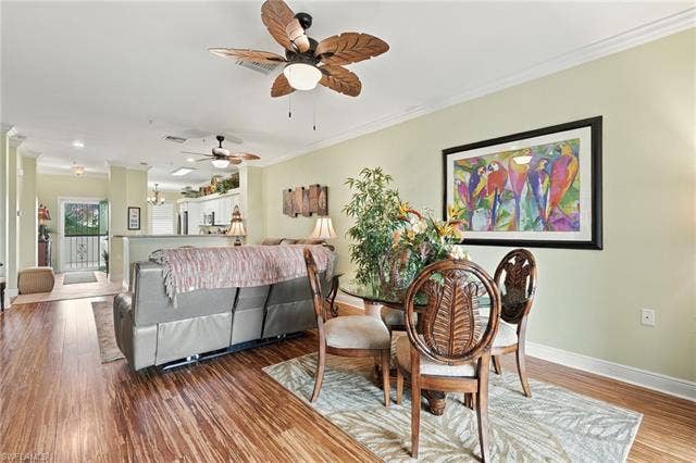 11041 Gulf Reflections Dr, #403, Fort Myers, FL 33908 Open-concept living area featuring wood-finish flooring, crown molding, and a decorative ceiling fan