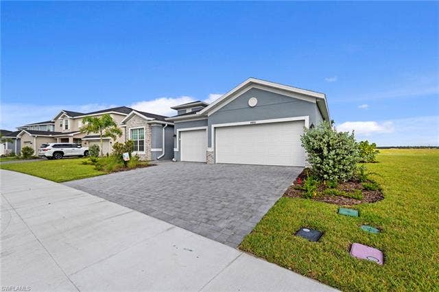 44810 Marina Ln, Punta Gorda, FL 33982 Contemporary stucco exterior with stone accents, a paver driveway, and a two-car garage