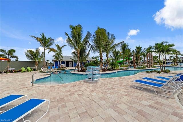 44810 Marina Ln, Punta Gorda, FL 33982 Resort-style aquatic amenity featuring a winding pool, surrounding paver patio, and established palm trees
