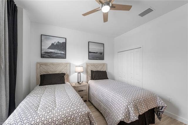 44810 Marina Ln, Punta Gorda, FL 33982 Light wood-finish flooring, ceiling fan with integrated lighting, wood-paneled headboards, and bi-fold closet doors