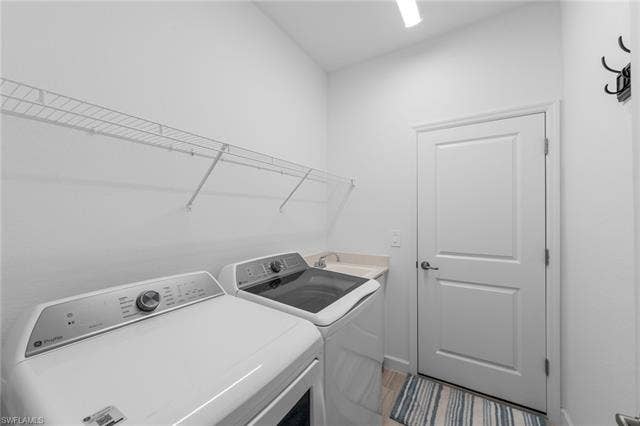 44810 Marina Ln, Punta Gorda, FL 33982 Dedicated laundry space featuring a wire shelving system, a built-in utility sink with a light-toned countertop, and light-colored flooring