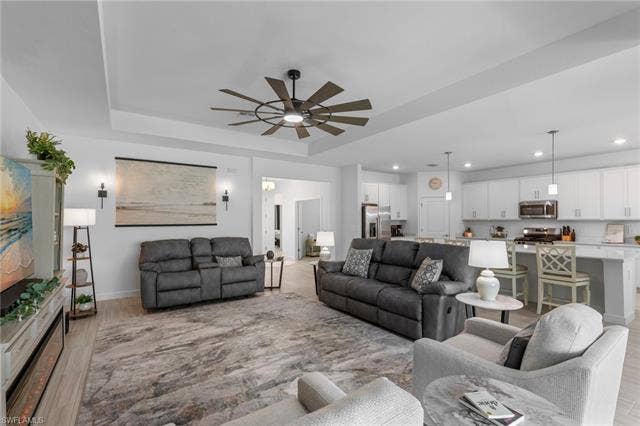 44810 Marina Ln, Punta Gorda, FL 33982 Tray ceilings with a ceiling fan, wood-finish flooring, recessed lighting, white cabinetry, and stainless steel appliances