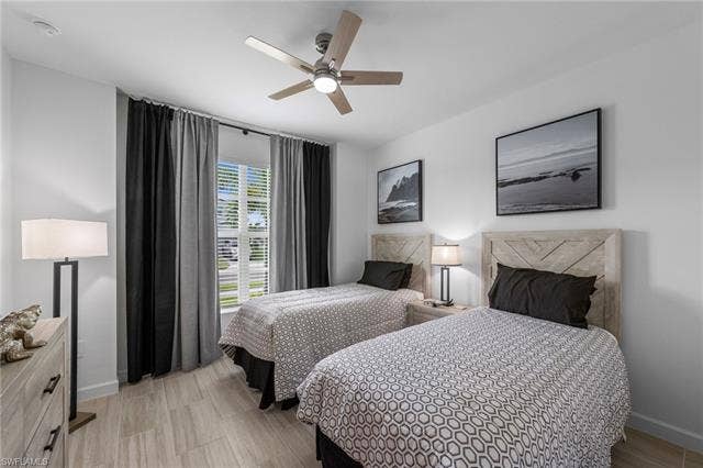 44810 Marina Ln, Punta Gorda, FL 33982 Ceiling fan with integrated lighting, window with horizontal blinds, wood-finish flooring, two wood headboards, and a built-in dresser
