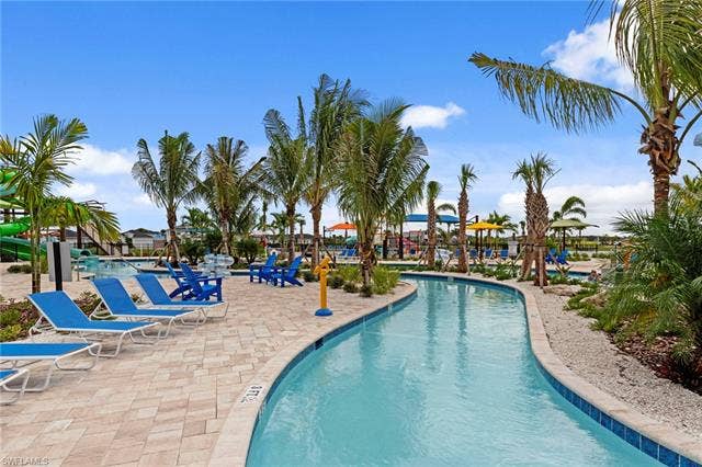 44810 Marina Ln, Punta Gorda, FL 33982 Lazy river with blue tile border, surrounded by palm trees and a paver deck