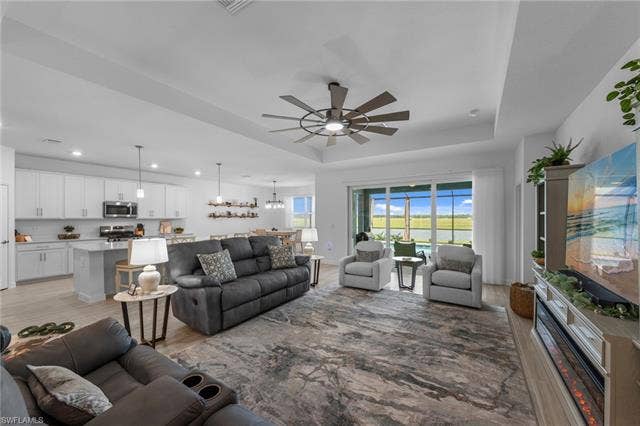 44810 Marina Ln, Punta Gorda, FL 33982 Open-concept living area with wood-finish flooring, a tray ceiling, and a ceiling fan