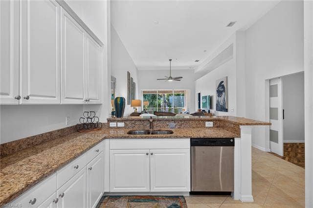 14543 Abaco Lakes Dr, #202, Fort Myers, FL 33908 Functional kitchen layout featuring a double basin sink and a raised breakfast bar that looks out across the living area to the patio.