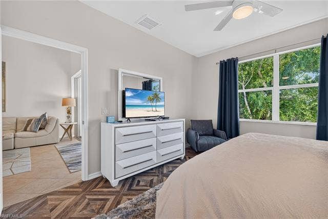 14543 Abaco Lakes Dr, #202, Fort Myers, FL 33908 Primary suite view showcasing the beautiful herringbone floors, private layout, large bright window, and direct access to the great room.