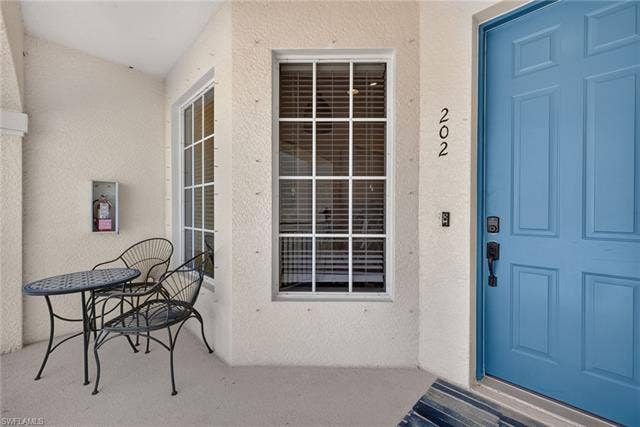 14543 Abaco Lakes Dr, #202, Fort Myers, FL 33908 Charming covered front porch entryway with cozy bistro seating