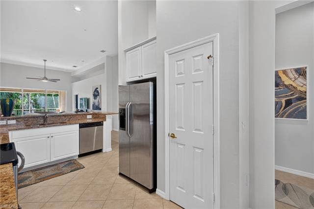 14543 Abaco Lakes Dr, #202, Fort Myers, FL 33908 Smart kitchen layout highlighting a modern stainless steel French-door refrigerator and a convenient built-in pantry closet for extra storage.