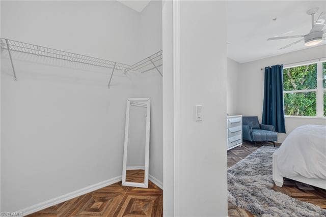14543 Abaco Lakes Dr, #202, Fort Myers, FL 33908 Second primary bedroom closet offering ample extra storage, continuous herringbone floors, and convenient proximity to the main sleeping space.