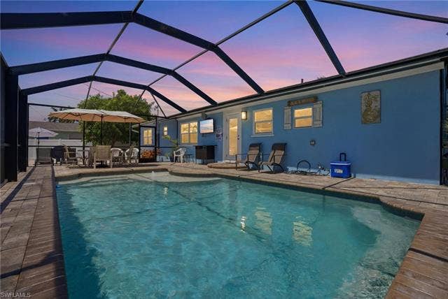 240 Fairweather Ln, Fort Myers Beach, FL 33931 Screen-enclosed swimming pool with a paved deck - Virtually Edited Image