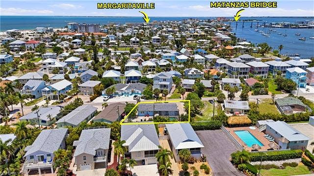 240 Fairweather Ln, Fort Myers Beach, FL 33931 Aerial perspective showcasing a coastal community with numerous residences - Virtually Edited Image
