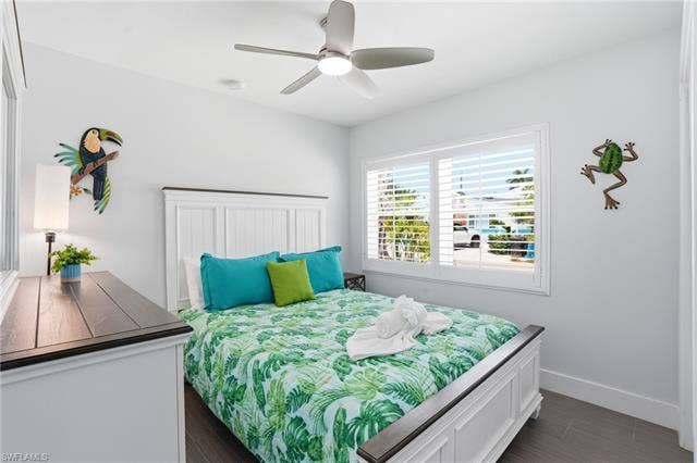 240 Fairweather Ln, Fort Myers Beach, FL 33931 Bedroom featuring a white paneled bed frame and matching dresser - Virtually Edited Image