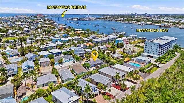 240 Fairweather Ln, Fort Myers Beach, FL 33931 Aerial perspective showcasing the property within a coastal community, featuring proximity to Matanzas Bay and the Matanzas Bridge - Virtually Edited Image