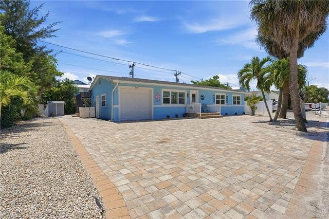 240 Fairweather Ln, Fort Myers Beach, FL 33931 Single-story residence featuring a light blue exterior with white trim - Virtually Edited Image