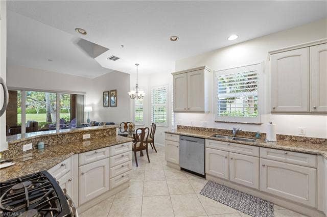 3142 Aviamar Cir, #2104, Naples, FL 34114 Chef's kitchen featuring white cabinetry, granite countertops, stainless steel appliances including a gas cooktop and dishwasher, pendant lighting, and abundant natural light from multiple windows
