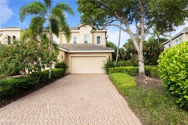 3142 Aviamar Cir, #2104, Naples, FL 34114 Stucco exterior with a tiled roof and a two-car garage