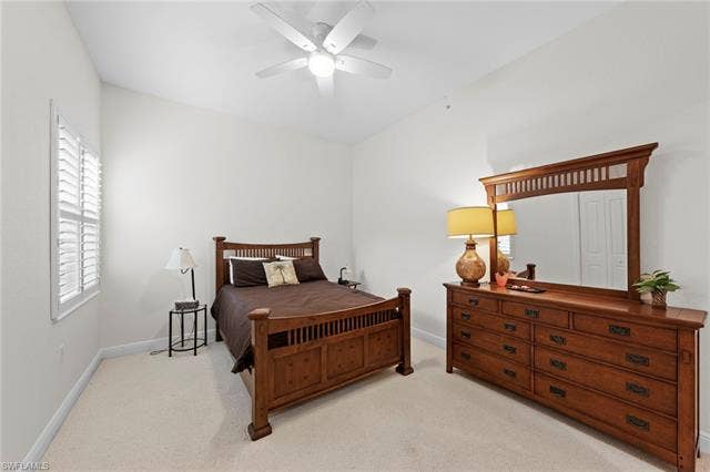 3142 Aviamar Cir, #2104, Naples, FL 34114 Angled ceiling, white ceiling fan with light fixture, carpeted flooring, window with white plantation shutters, white walls