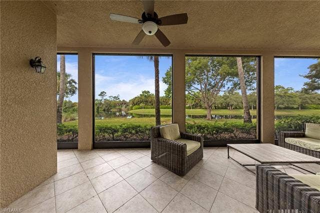 3142 Aviamar Cir, #2104, Naples, FL 34114 Screened patio with large format tile flooring, a ceiling fan, and sconce lighting