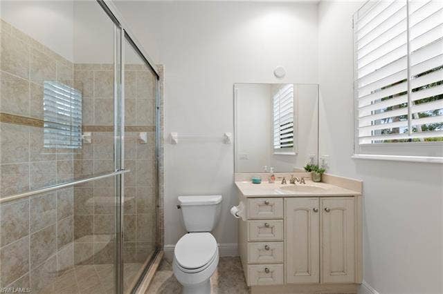 3142 Aviamar Cir, #2104, Naples, FL 34114 Glass-enclosed shower with tiled walls and built-in bench