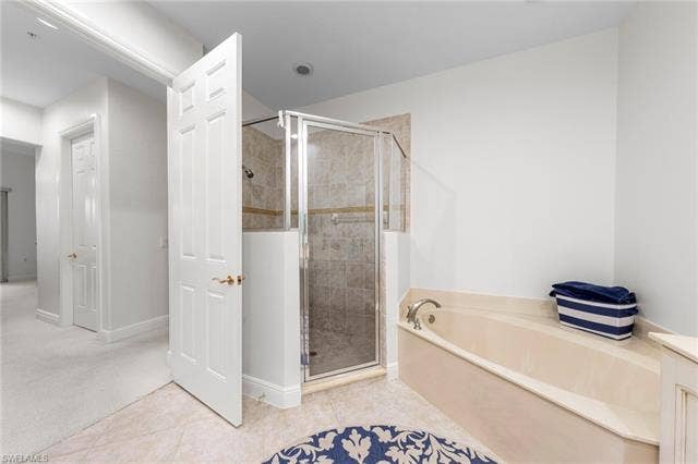 3142 Aviamar Cir, #2104, Naples, FL 34114 Recessed lighting, tile flooring, glass-enclosed shower, built-in bathtub, and panel doors