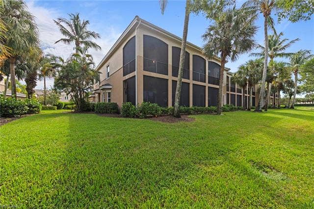 3142 Aviamar Cir, #2104, Naples, FL 34114 Exterior featuring multiple screened balconies, stucco siding, and surrounding mature palm trees
