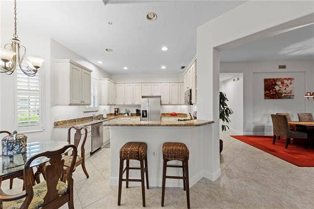 3142 Aviamar Cir, #2104, Naples, FL 34114 Kitchen featuring white cabinetry, stainless steel appliances, and granite countertops