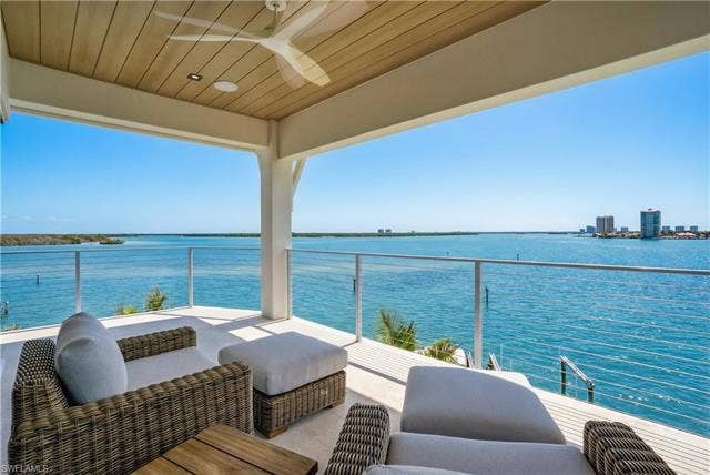 280 Estrellita Dr, Fort Myers Beach, FL 33931 Balcony with a water view, a ceiling fan, and outdoor furniture - Virtually Edited Image