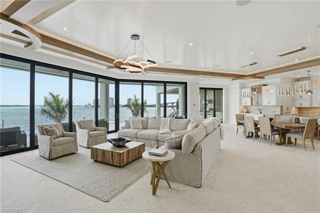 280 Estrellita Dr, Fort Myers Beach, FL 33931 Living area featuring hanging lights, a water view, and a raised ceiling - Virtually Edited Image
