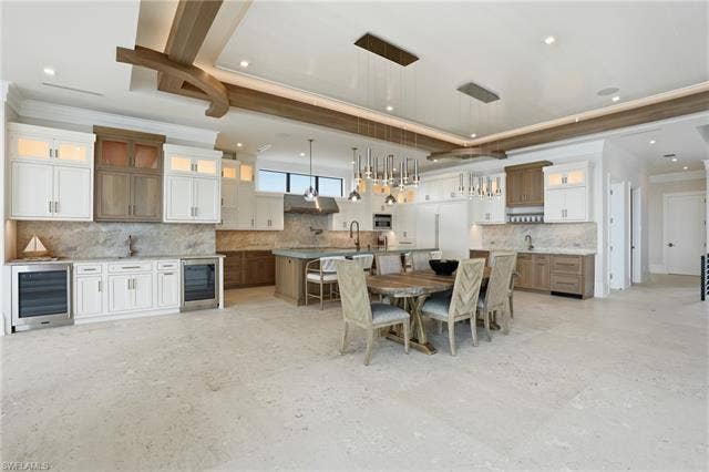 280 Estrellita Dr, Fort Myers Beach, FL 33931 Dining room with ornamental molding, beverage cooler, a raised ceiling, and recessed lighting - Virtually Edited Image