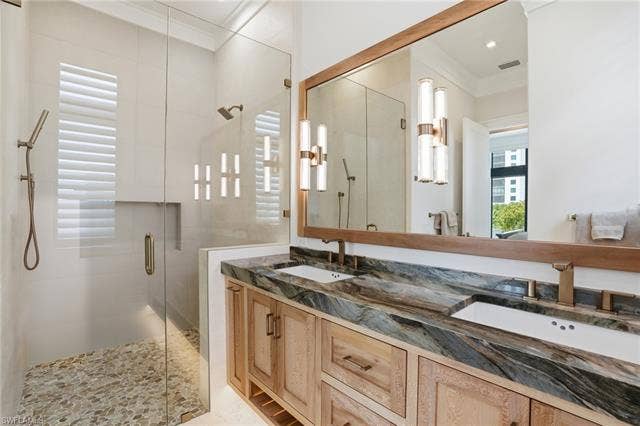 280 Estrellita Dr, Fort Myers Beach, FL 33931 Full bath with a shower stall, double vanity, and ornamental molding - Virtually Edited Image