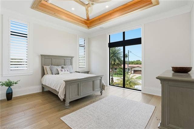 280 Estrellita Dr, Fort Myers Beach, FL 33931 Bedroom with light wood-type flooring and crown molding - Virtually Edited Image