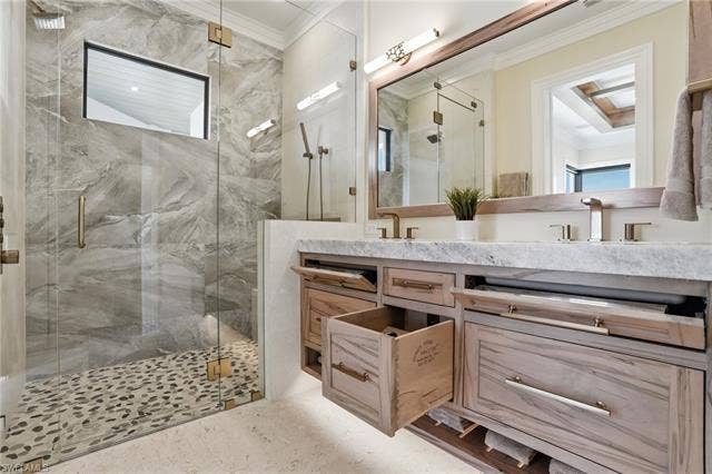 280 Estrellita Dr, Fort Myers Beach, FL 33931 Full bathroom with ornamental molding, double vanity, and a marble finish shower - Virtually Edited Image