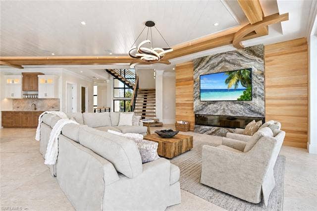 280 Estrellita Dr, Fort Myers Beach, FL 33931 Expansive open-concept living area showcasing soaring wood beam ceilings, recessed lighting, and a contemporary pendant fixture - Virtually Edited Image