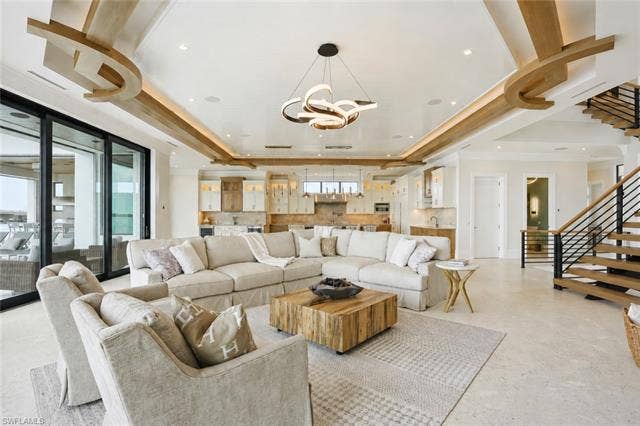 280 Estrellita Dr, Fort Myers Beach, FL 33931 Spacious open-concept living area featuring a coffered ceiling with integrated lighting and decorative wood accents - Virtually Edited Image
