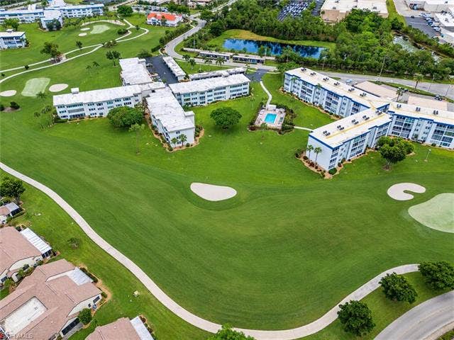 6220 Augusta Dr, #117, Fort Myers, FL 33907 Community featuring golf course access, multiple residential buildings, swimming pool, and a pond