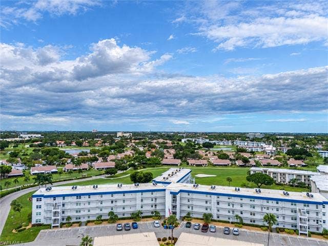 6220 Augusta Dr, #117, Fort Myers, FL 33907 Mid-rise building with a white facade and blue accents, situated on a landscaped property with a parking area