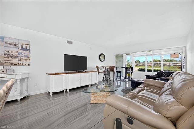 6220 Augusta Dr, #117, Fort Myers, FL 33907 Large format tile flooring, white walls, and an expansive window line