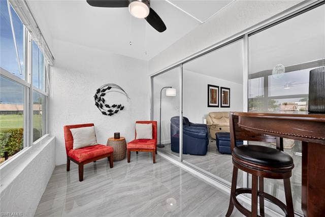 6220 Augusta Dr, #117, Fort Myers, FL 33907 Enclosed patio featuring large windows, a ceiling fan, and sliding glass doors