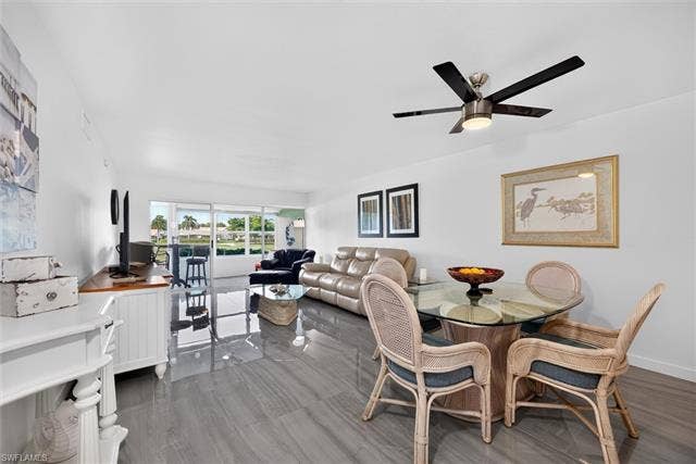 6220 Augusta Dr, #117, Fort Myers, FL 33907 Open-concept living space featuring tile flooring, a ceiling fan with integrated lighting, and direct access to an outdoor area through sliding glass doors